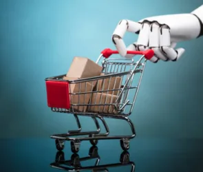 Robot Holding Shopping Cart With Cardboard Boxes On Turquoise Background