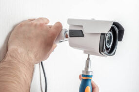 Technician worker installing video surveillance camera CCTV camera closeup